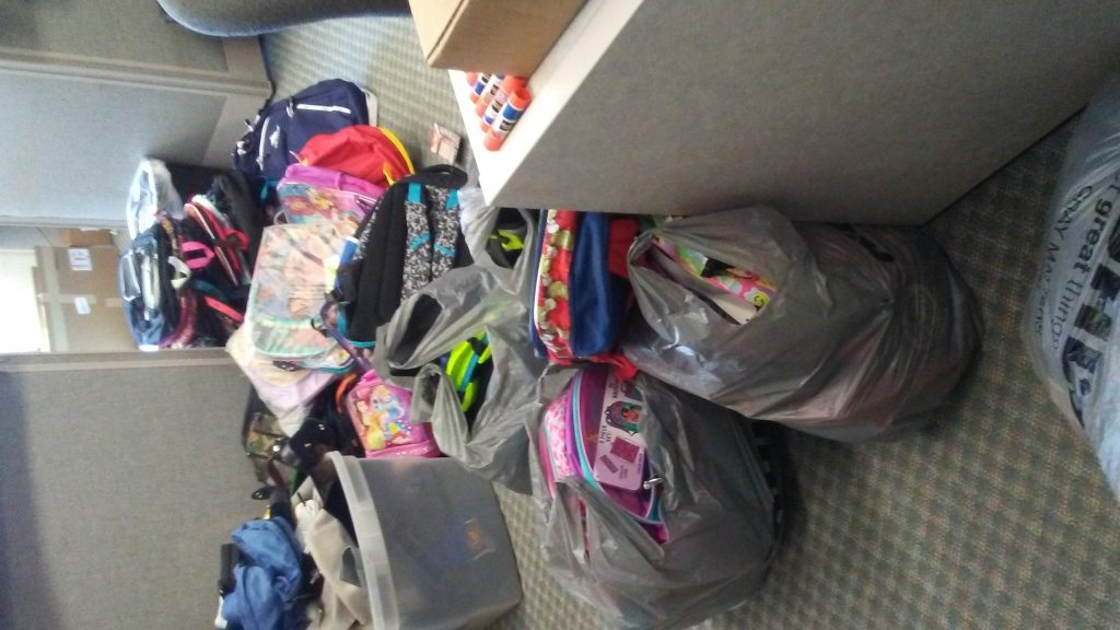 Piles of donated backpacks in the Madison Heights Hazel Park Chamber Office